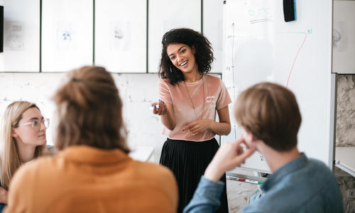 Women standing in front of other people speaking