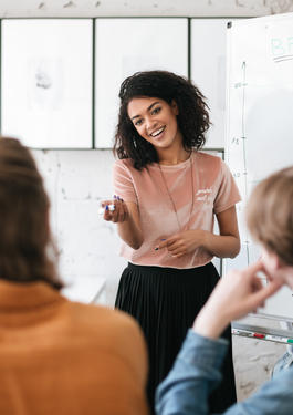 Women standing in front of other people speaking