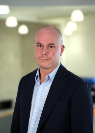 Man med stickad blå tröja och glasögon